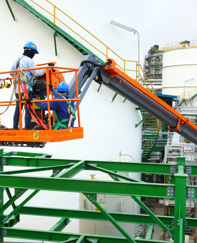 Worker are driving the Orange articulate boom lift or telescopic boom lifts and bucket crane mounted on truck to safety for working at heights and articulating boom lift reaching high up.